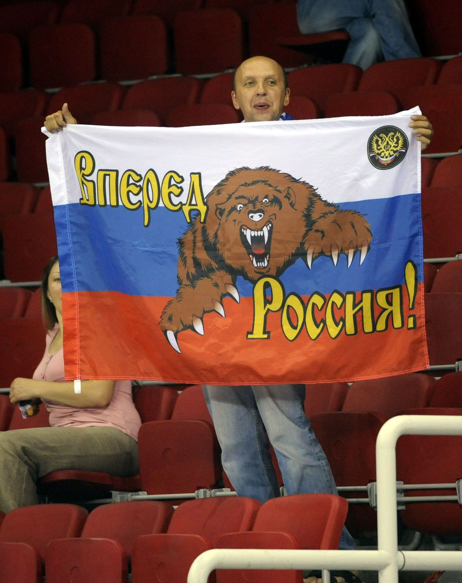 Mees Venemaa lipuga, millel on Vene karu ja tekst: «Edasi Venemaa!»