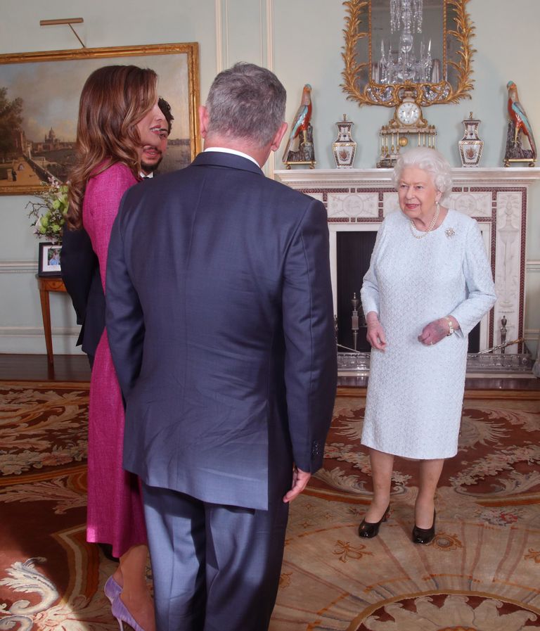 Briti kuninganna Elizabeth II vestlemas Jordaania kuninganna Rania ja kuninga Abdullah II. Elizabeth II vasakul käel on näha lillakaspunast laiku