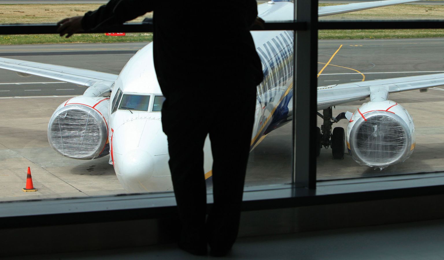 Ryanairi lennuk Belfast City lennuväljal 20. aprillil reisija silueti taustal.