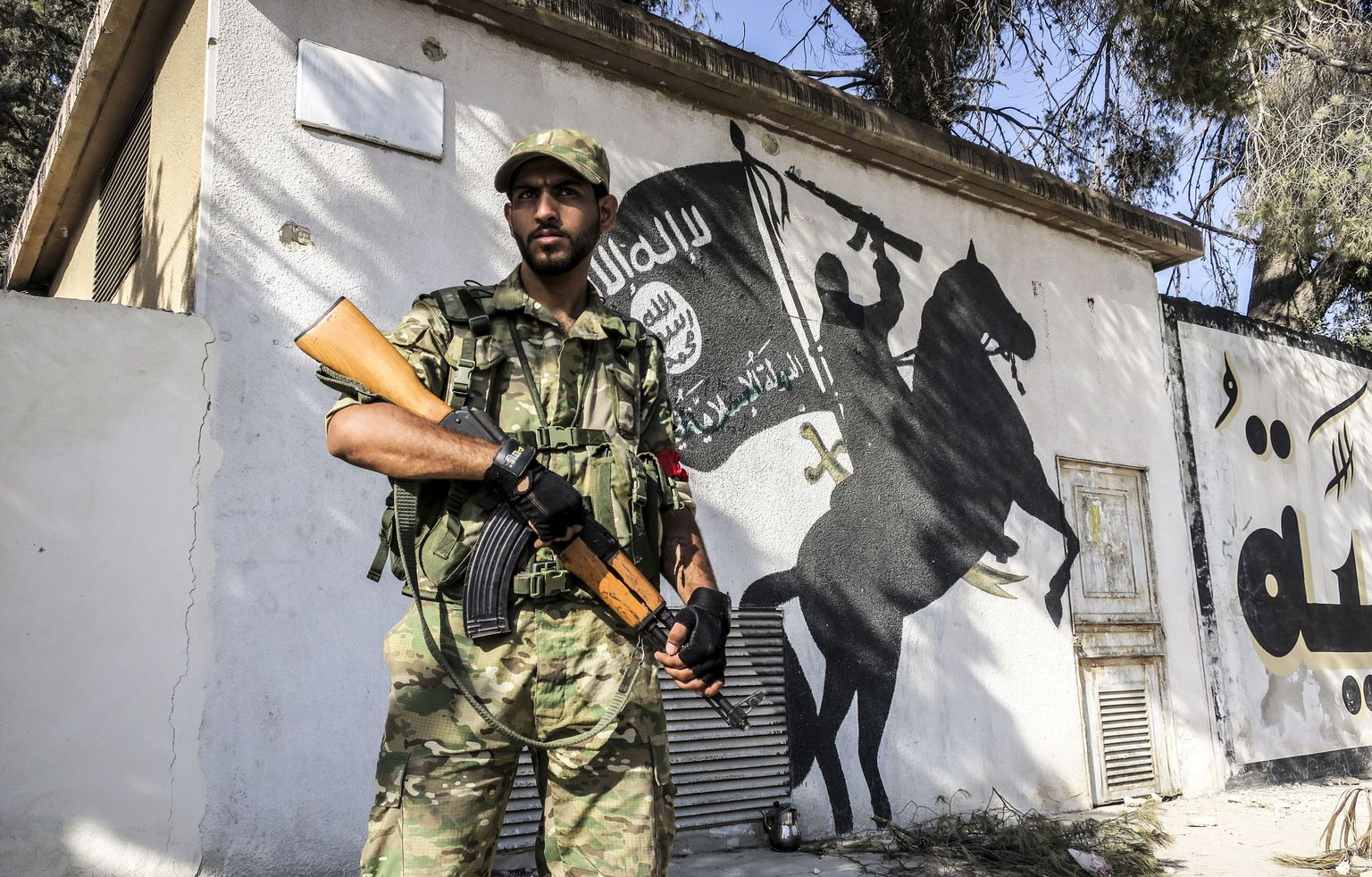 Ankara-meelne mässuline seismas seinale joonistatud ISISe seinamaalingu ees Jarabulusi linnas.