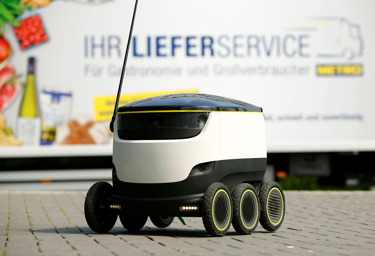 A conventional delivery truck of Germany's biggest retailer Metro AG stands behind the world's first commercial delivery robot of Starship Technologies during a demonstration at Metro's headquarter in Duesseldorf, Germany, June 7, 2016. The six-wheels electrical delivery robot designed by the Skype founders Ahti Heinla and Janus Friis can autonomously navigate and carry a maximum load of 20 kilograms over a distance of six kilometres from its base station at a maximum speed of 6 km/h.  REUTERS/Wolfgang Rattay