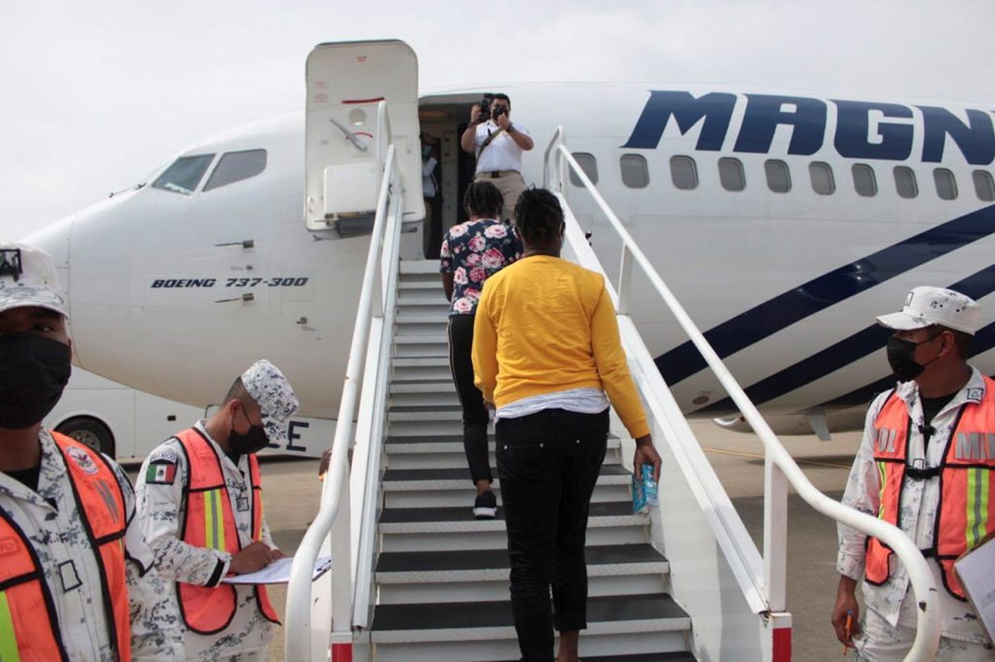 Haiti migrandid Mehhikos lennukile minemas.
