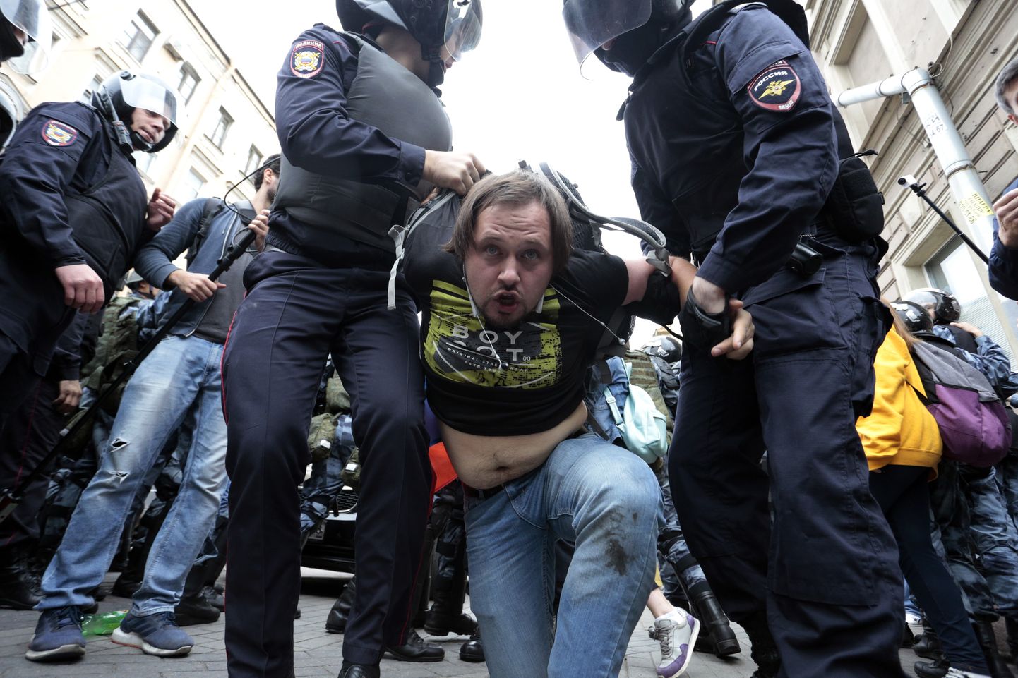 Российские полицейские задерживают участника акции протеста в Санкт-Петербурге.