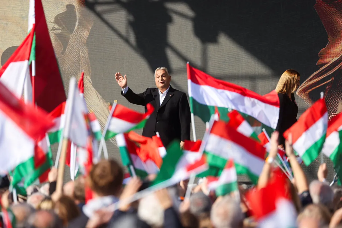 Hungarian Prime Minister Viktor Orbán waves during a speech marking the 68th anniversary of the 1956 Uprising in Budapest on October 23, 2024. History has a strange sense of humor.