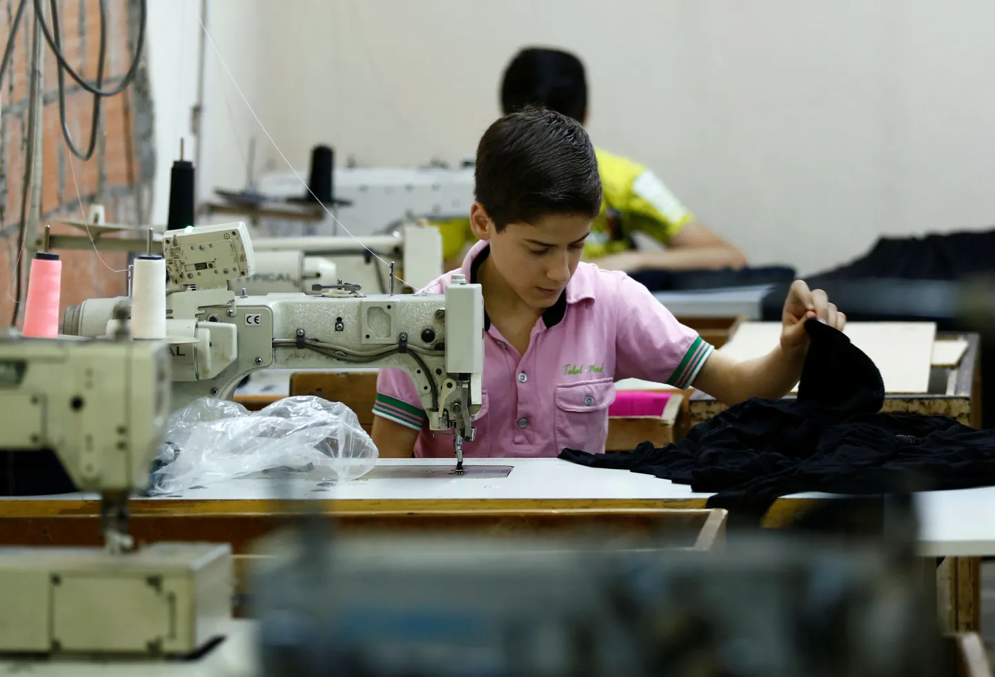 Süüria pagulaspoiss Istanbuli tekstiilitehases tööl.