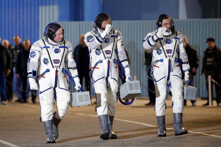 Vasakult: USA astronaut Scott Kelly ning Venemaa kosmonaudid Mihhail Kornienko and Gennadi Padalka 27. märtsil 2015 enne lendu rahvusvahelisse kosmosejaama. Neil on seljas skafander, millel lukk on V-kujuliselt
