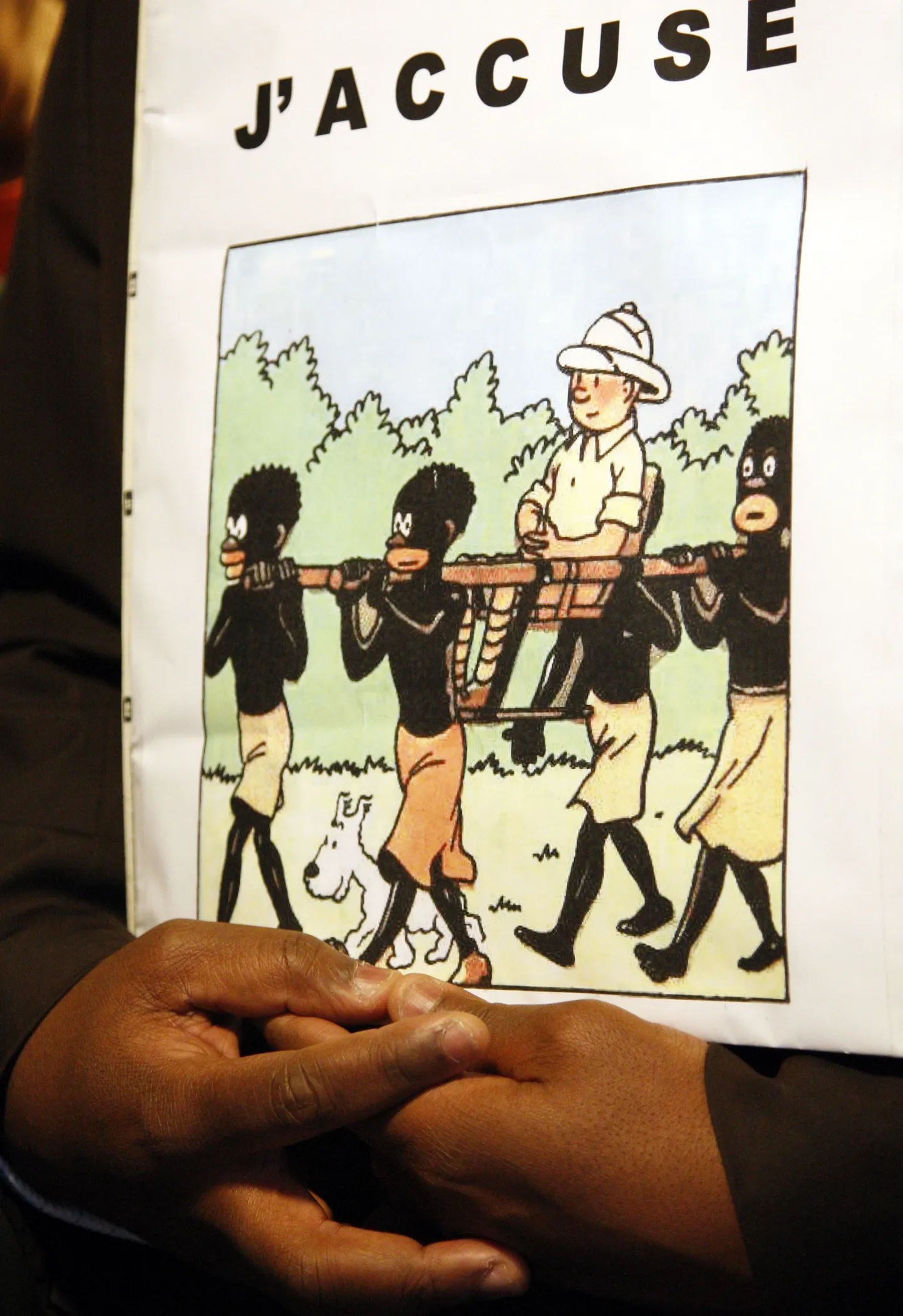 Tintini rassismis süüdistav plakat Bienvenu Mbutu Mondondo käes.