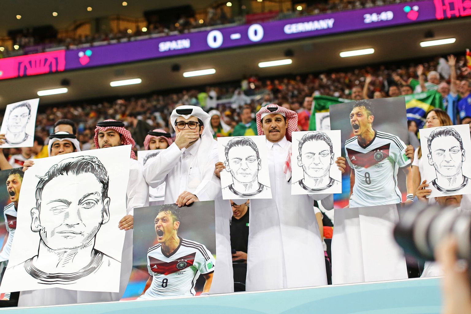 Kataris jalgpalli MMi 27. novembri 2022 kohtumise ajal Hispaania ja Saksamaa vahel nähti protesti Saksamaa koondise vastu. Katari jalgpallifännide käes olid Saksa endise koondislase, Türgi juurtega Mesut Özili pildid