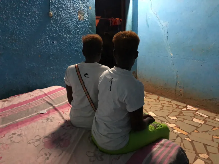 Kaks inimkaubanduse ohvrit Nigeeriast, keda on sunnitud prostitutsioonile istuvad Burkina Fasos asuva baari voodil.