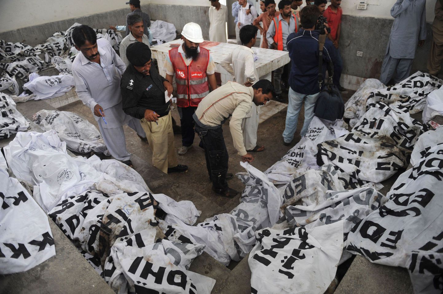 Pakistani parameedikud ja päästeametnikud Karachi rõivavabriku põlengu ohvreid uurimas.