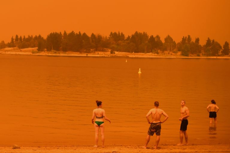 Jindabyne'i elanikud käivad järves suplemas, et ennast jahutada. Taevas on maastikupõlengute suitsust punane.
