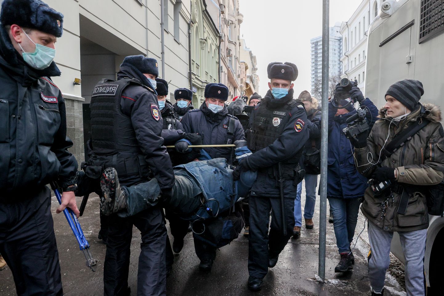 Vene politseinikud Memoriali toetajat kohtuhoone eest minema toimetamas.