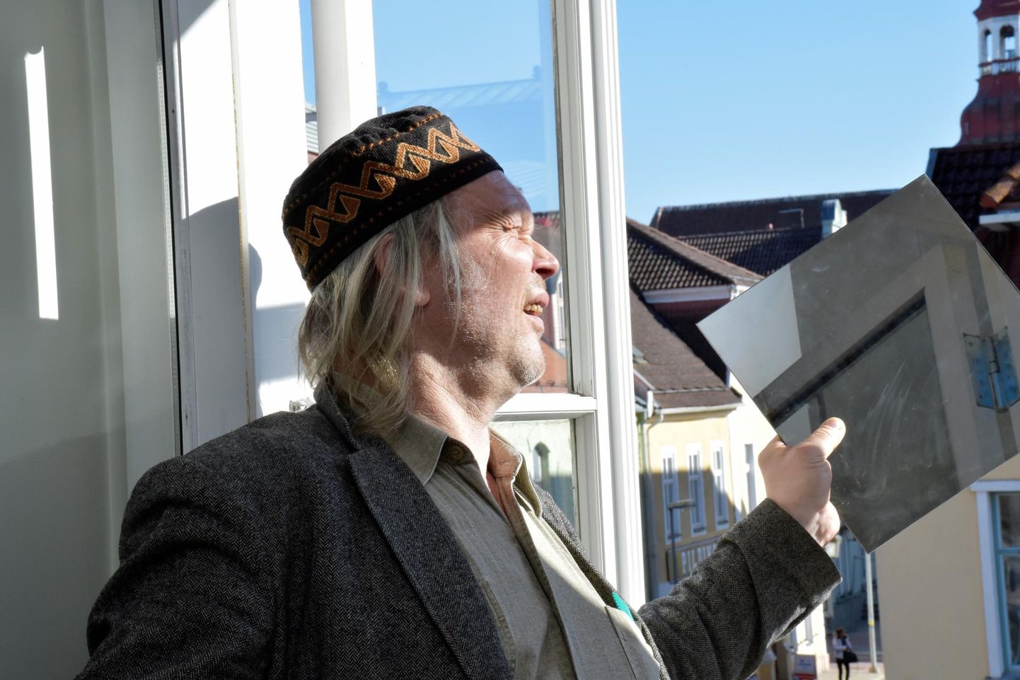 Margus Tiitsmaa püüdmas Pärnu linnagalerii aknast päikesevalgust. Alar Raudoja