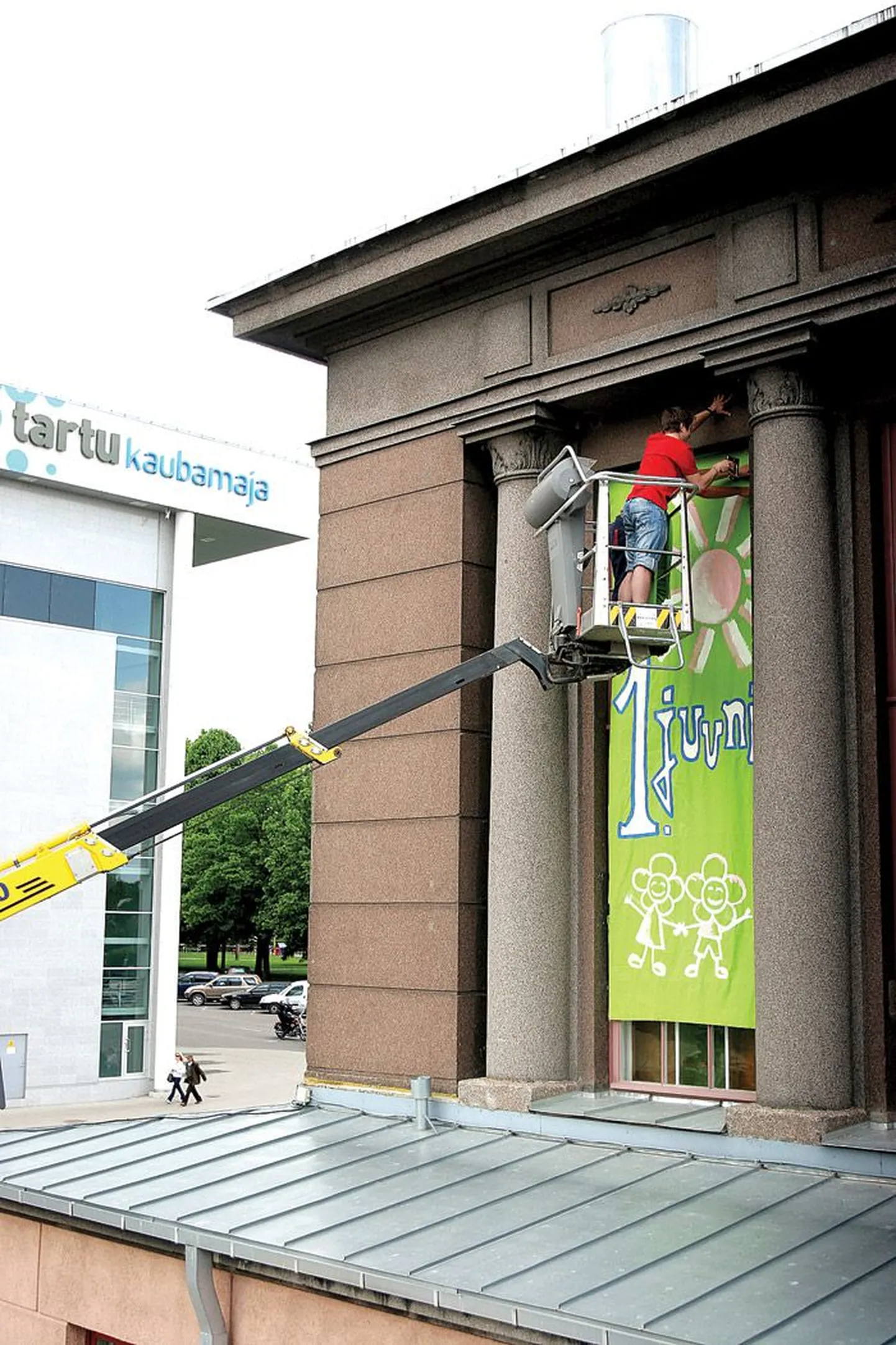Teisipäeval panid Lille maja noored tõstukiga helerohelisi plakateid turuhoone seinale, pildil kinnitab plakatit soomlasest praktikant Toni Kanerva.