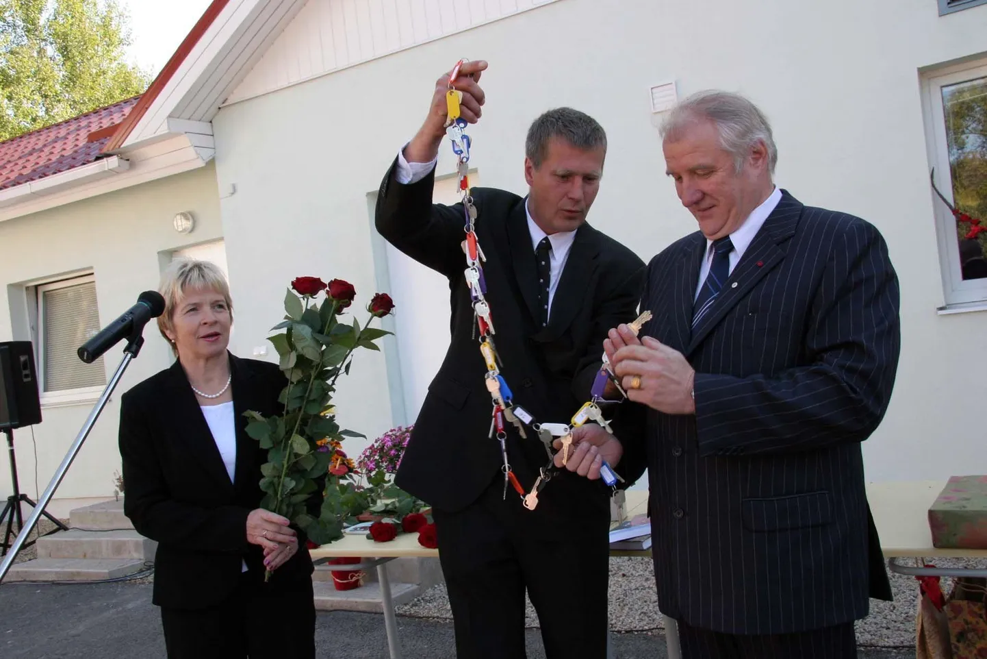 2013. aastal Lõuna-Eesti Hooldekeskuse ees hoone ehitaja ja tollel ajal Pinnatöötluse OÜ juhatuse esimees Ake Andressoo (praegune MTÜ Hellenurme Jahiseltsi juht) annab uue maja tubade võtmed üle MTÜ Hellenurme Mõis direktorile Vambola Sipelgale (EKRE). FOTO: Heino Käos