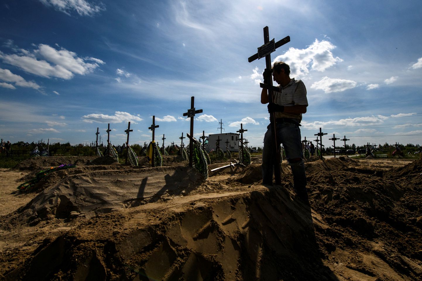 Vabatahtlik paigutab risti hukkunule, kelle Vene sõdurid Butšas tapsid