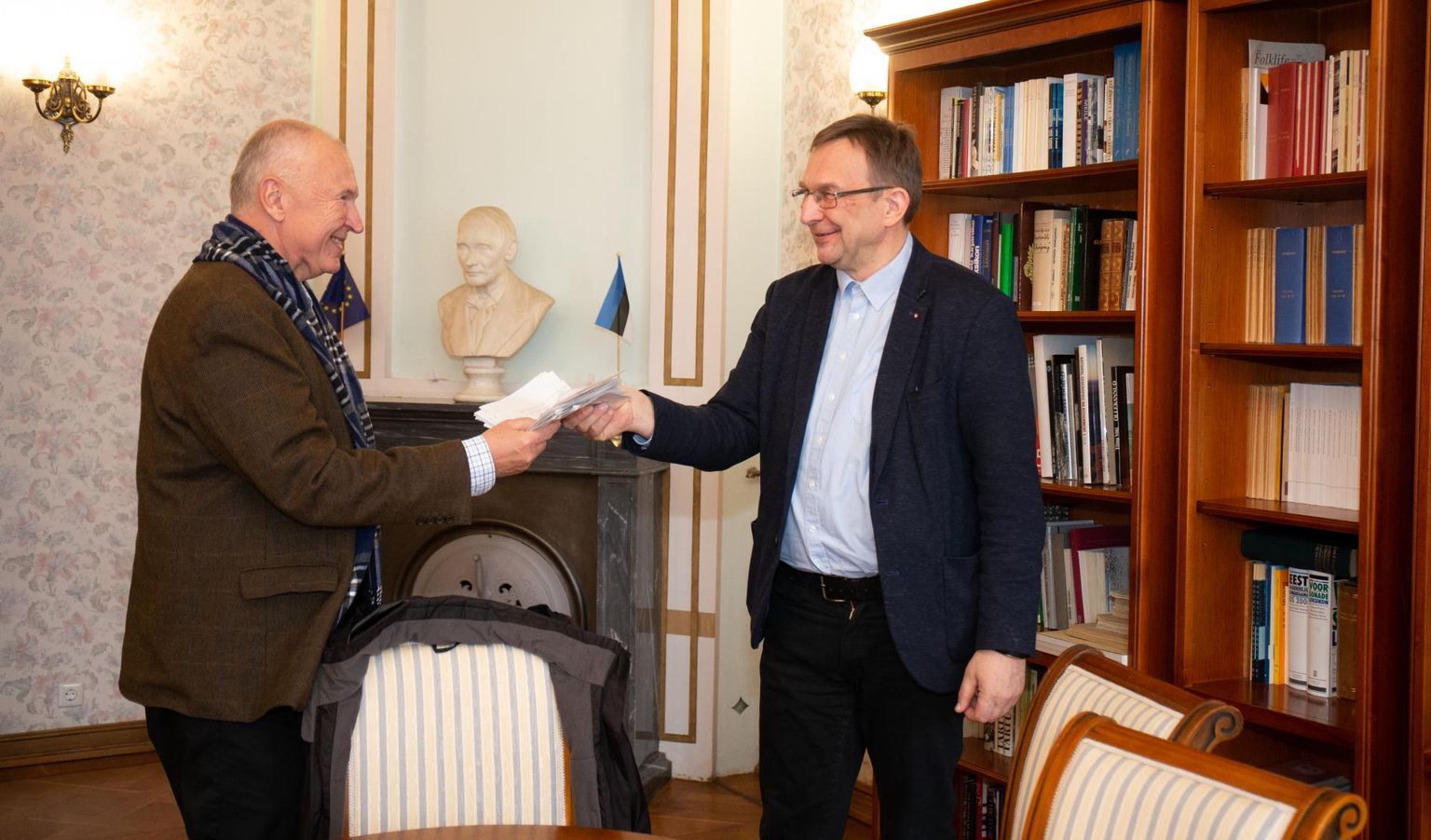 Indrek Hirv (vasakul) andis Eesti kirjandusmuuseumis pahmaka vihikulehti, millel tema selle talve luuletused, direktor Urmas Sutropile.