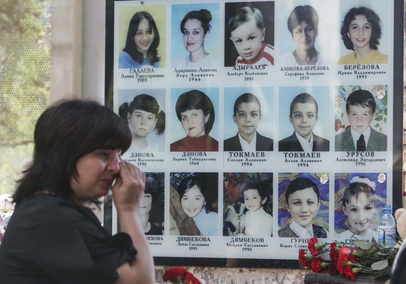 Женщина плачет перед фотографиями детей, убитых во время штурма школы номер 1 города Беслан в сентябре 2004 года. В результате теракта, когда более тысячи человек удерживались террористами в школе трое суток, погибли более 330 человек, в том числе 186 детей.
