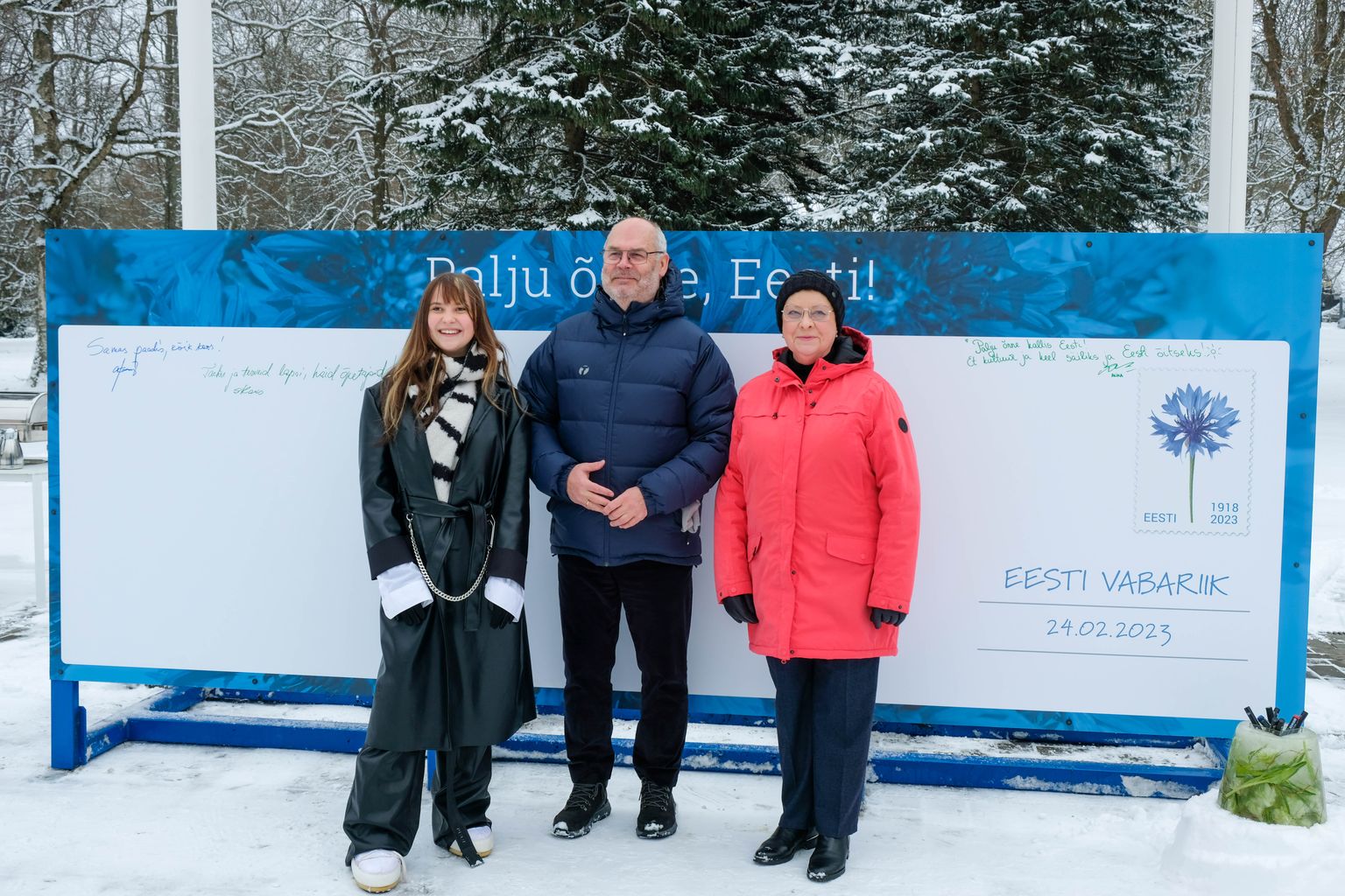 President Alar Karis, Sirje Karis (paremal) ja Alika Milova avasid Eesti sünnipäeva nädala puhul presidendi kantselei esisel lipuplatsil sünnipäevakaardi.