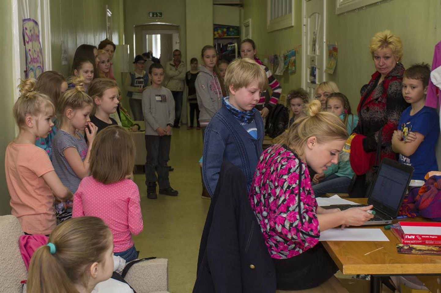 Koridoris jagas assistent Heli Jürisson proovivõttele tulnud lastele rinda numbriga kleebised.