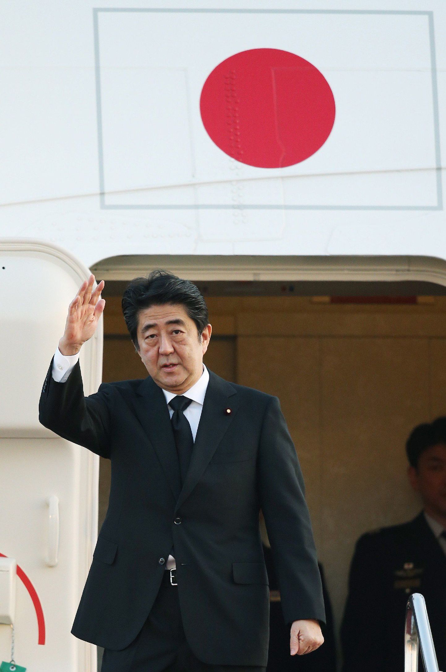 Japanese Prime Minister Shinzo Abe waves as he leaves for Singapore from the Tokyo International Airport on March 29, 2015.  Abe will attend the state funeral of Singapore's founding leader Lee Kuan Yew.   AFP PHOTO / JIJI PRESS    JAPAN OUT