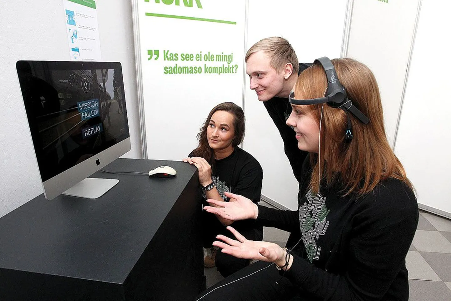 Tartu kõrgema kunstikooli meedia- ja reklaamikunstitudengid Piret Alvre (esiplaanil), Priit Joasoo ja Catherine Karu näitavad galeriis Noorus, kuidas mängida nende loodud interaktiivset mängu «Rush» ajulainetelugeja MindWave’i abil.