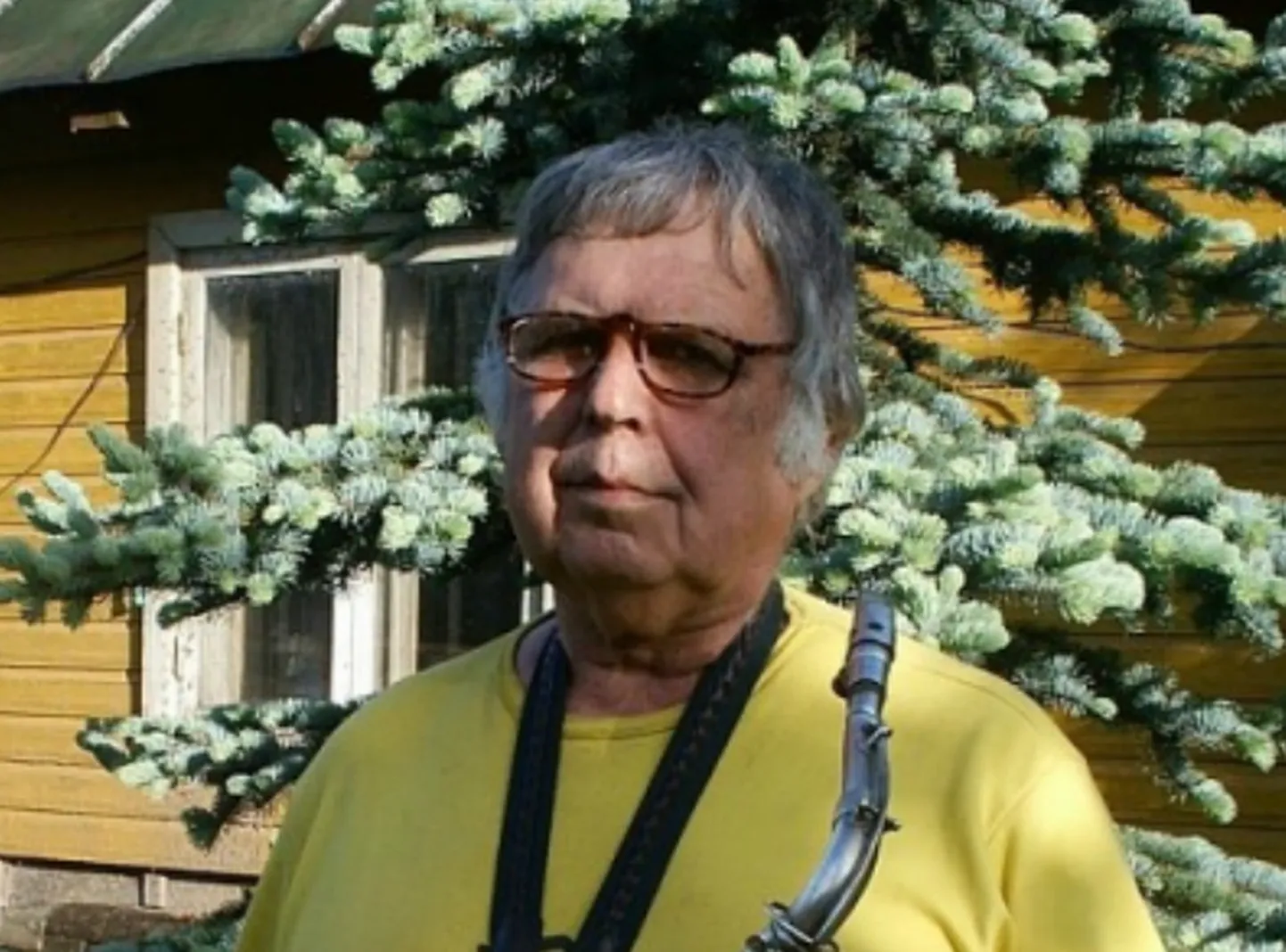 Aadu Birnbaum saksofoniga oma maja juures.