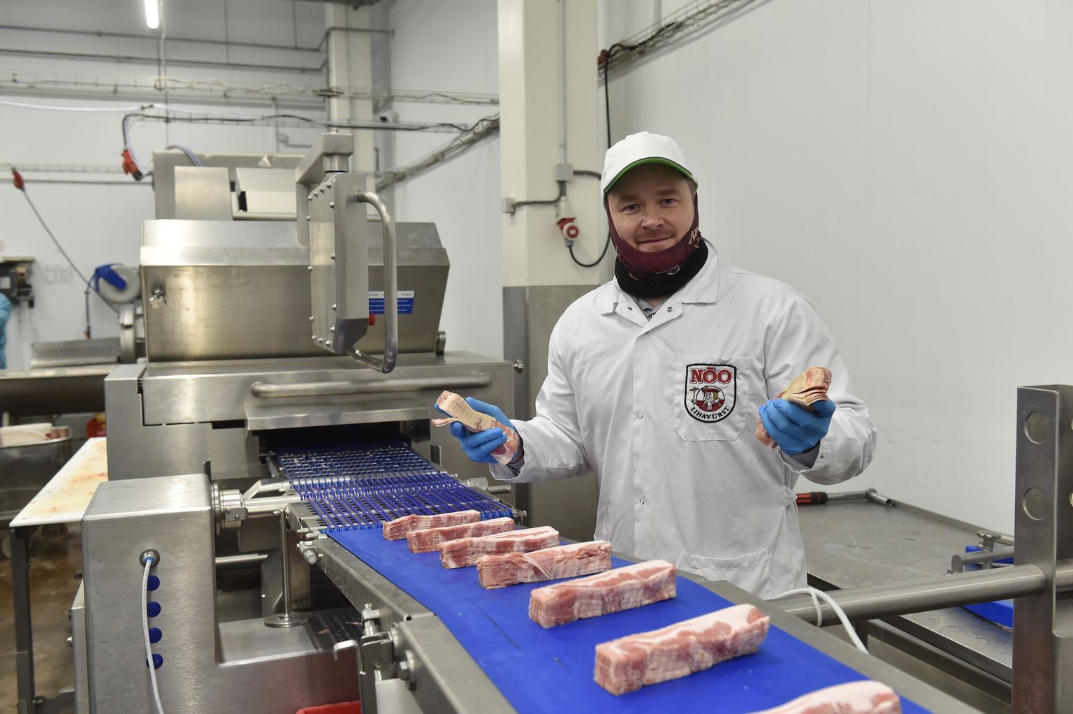 Nõo Lihatööstuse tegevjuht Ragnar Loova näitab uut tootmisliini, mis võimaldab Eestis esimesena turule tulla kodumaise toorsuitsupeekoniga.