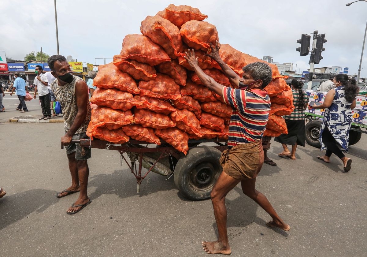 Strādnieki krauj ratos sīpolu maisus Šrilankas galvaspilsētā Kolombo.