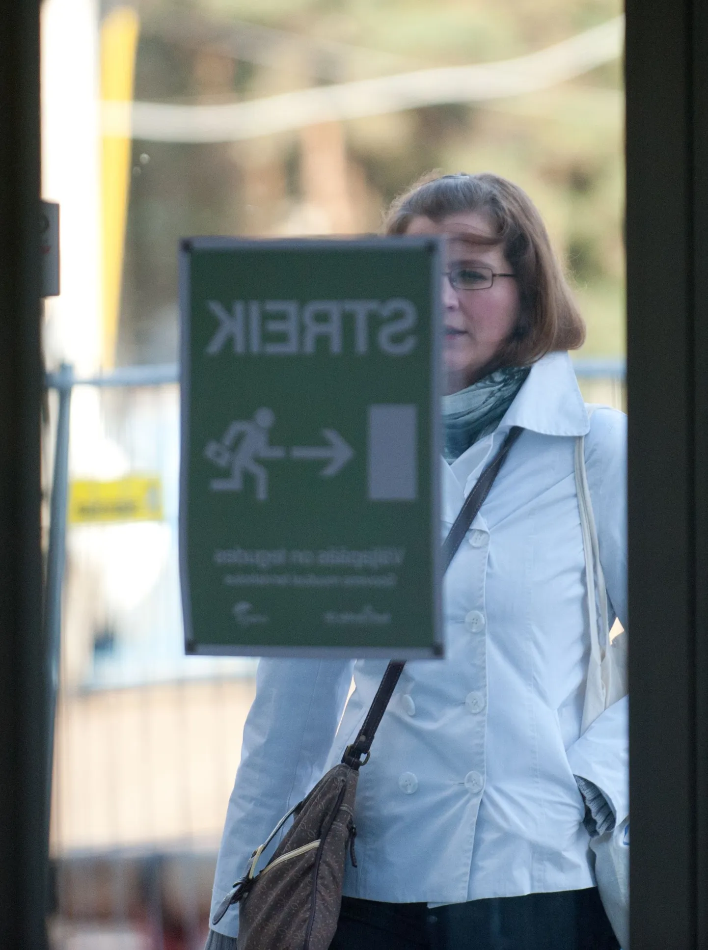 Naine Mustamäel Põhja-Eesti regionaalhaigla uksel steigiteadet lugemas.