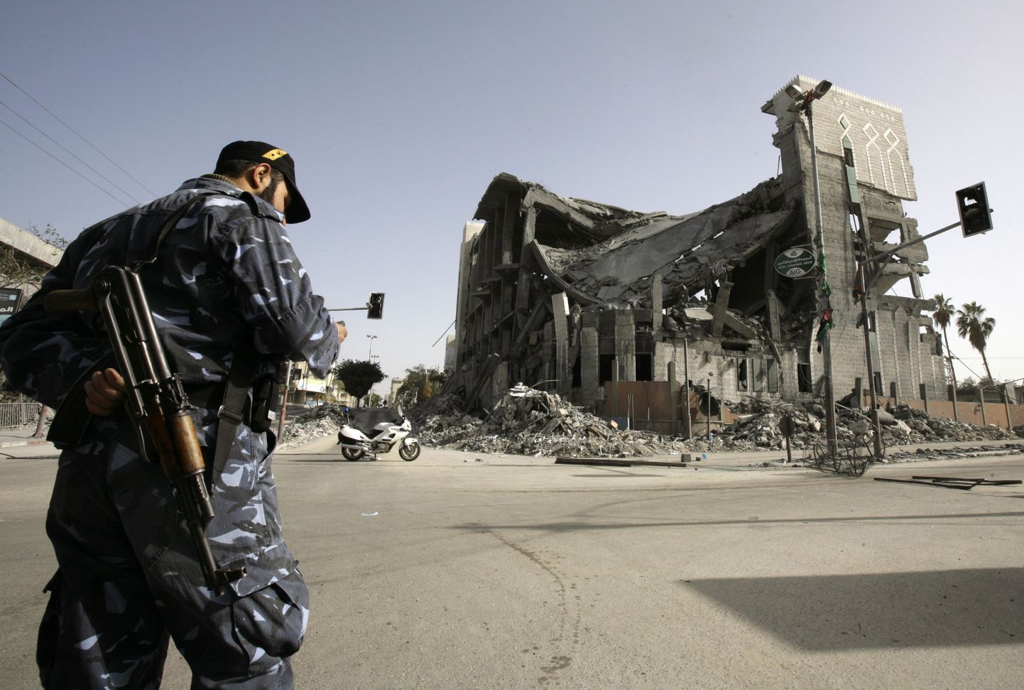 Hamasi politseiohvitser seismas Iisraeli rünnaku ajal hävitatud parlamendihoone kõrval Gazas.