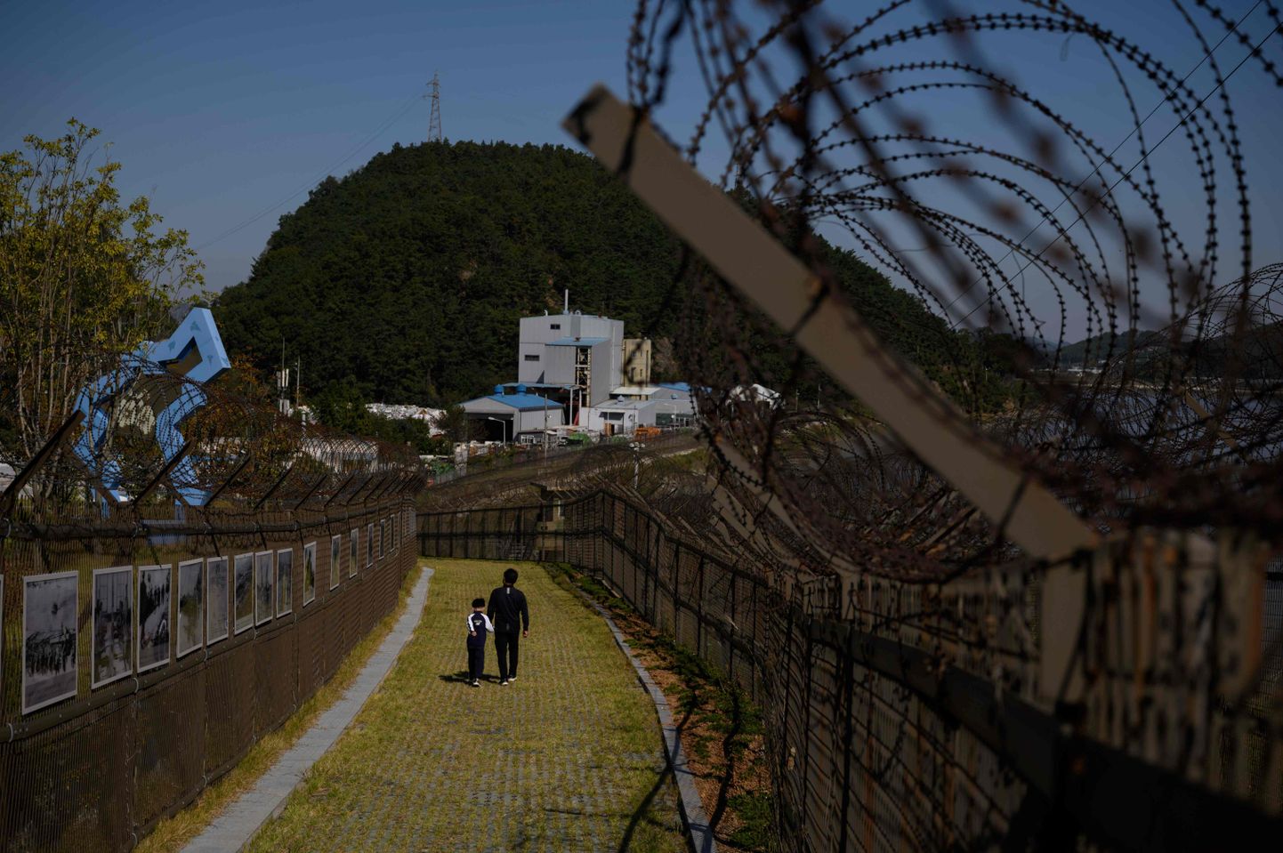 Jalutajad Põhja- ja Lõuna-Koread eraldava demilitariseeritud tsooni aia ääres.