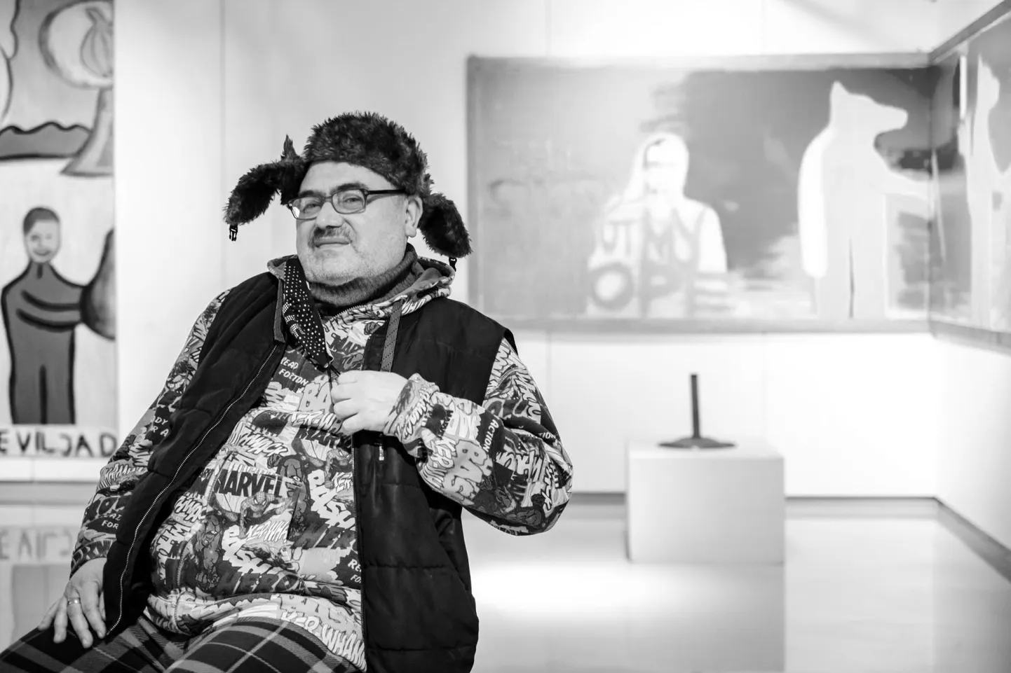 Andrus Joonas oma veebruarikuisel retrospektiivsel juubelinäitusel “Meelesurfar” Pärnu muuseumis, tagant maalil paistmas Kollane Huntmees.