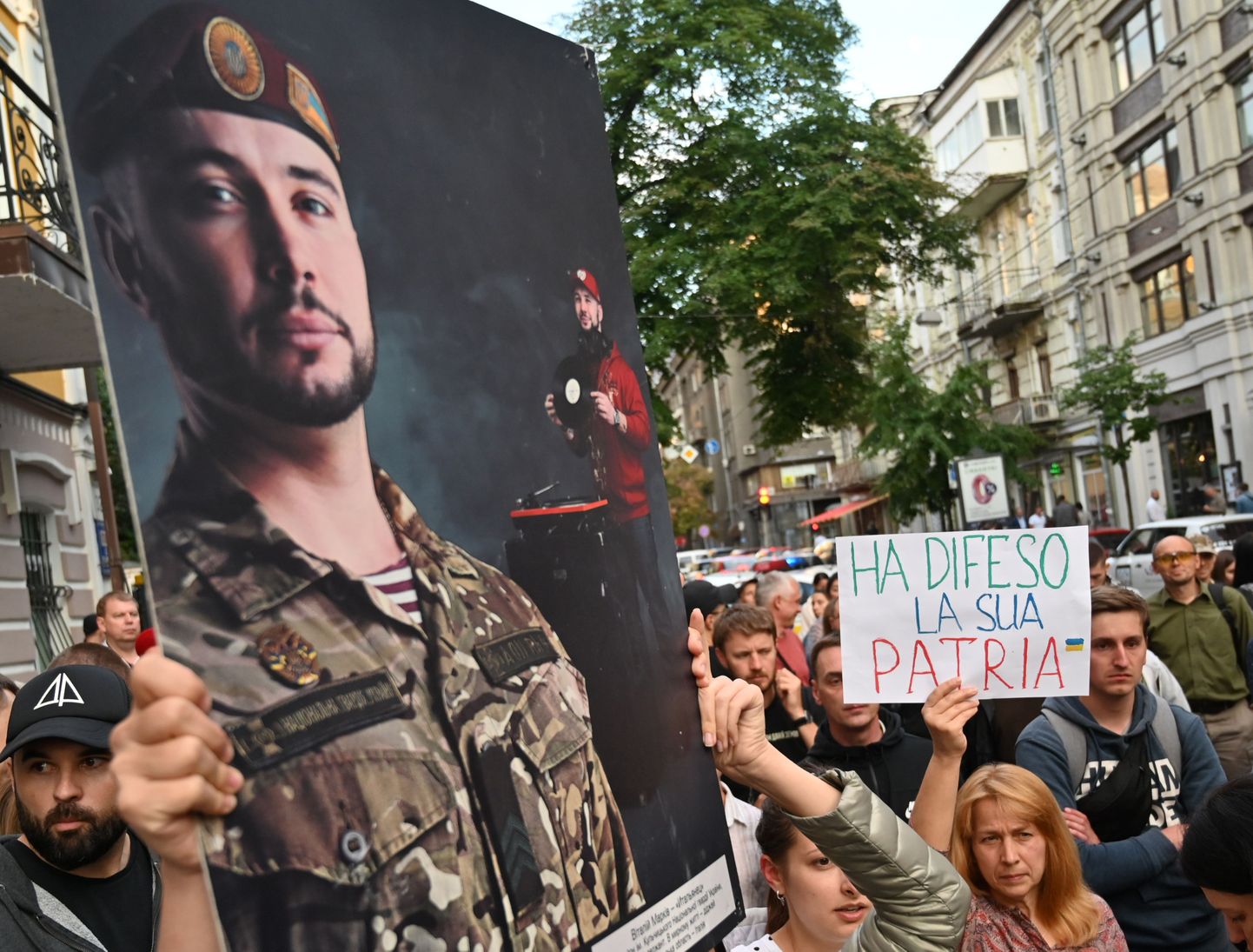 Aktivistid hoiavad pilti, millel kujutatakse Ukraina sõjaväelast Vitali Markivit, samal ajal avaldavad meelt,loosungitega "Vabastage Markiv!". Meeleavaldus toimus 2019. aastal Itaalias Kiievi saatkonna ees.
