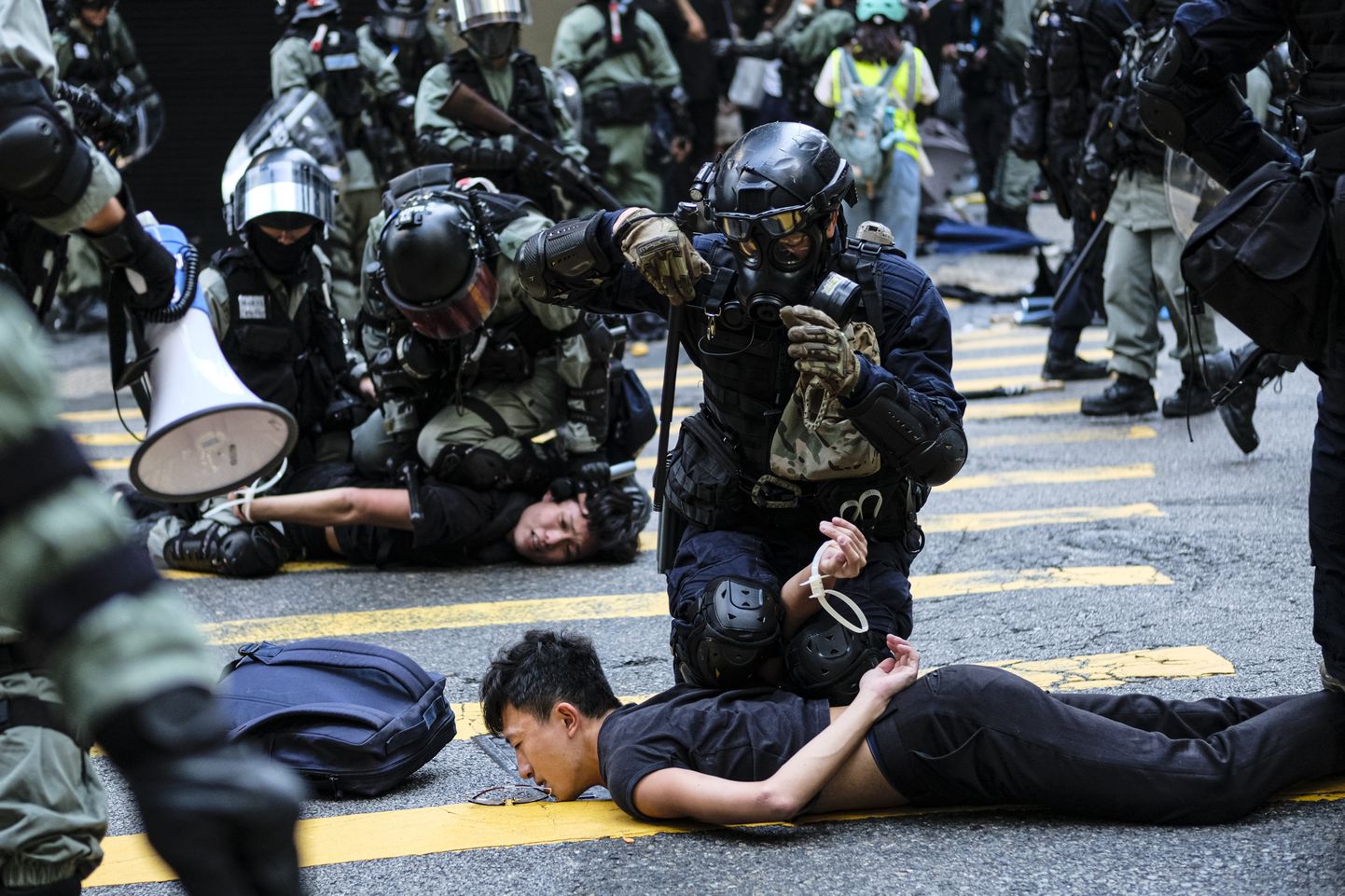 Märulipolitseinikud Hongkongi kesklinnas meeleavaldajaid kinni pidamas.