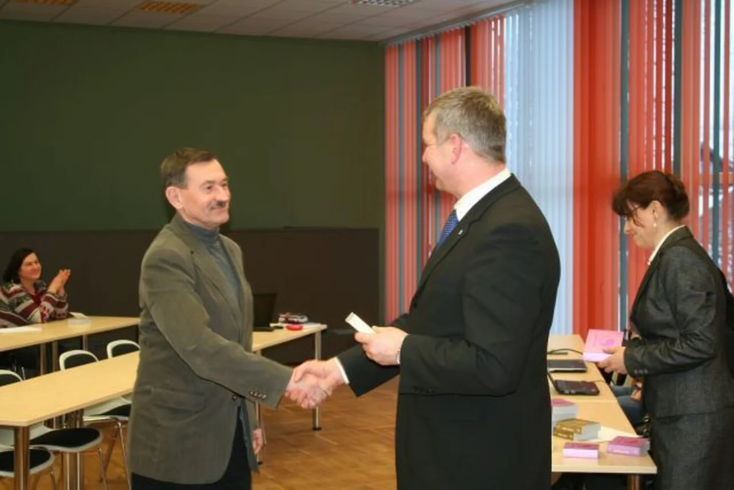 Viljandi maavanem Lembit Kruuse kutsus vastuvõtule kõik 31 Viljandimaa perearsti ja kinkis neile raamatu. Fotol tänab maavanem perearst Henn Seppa.