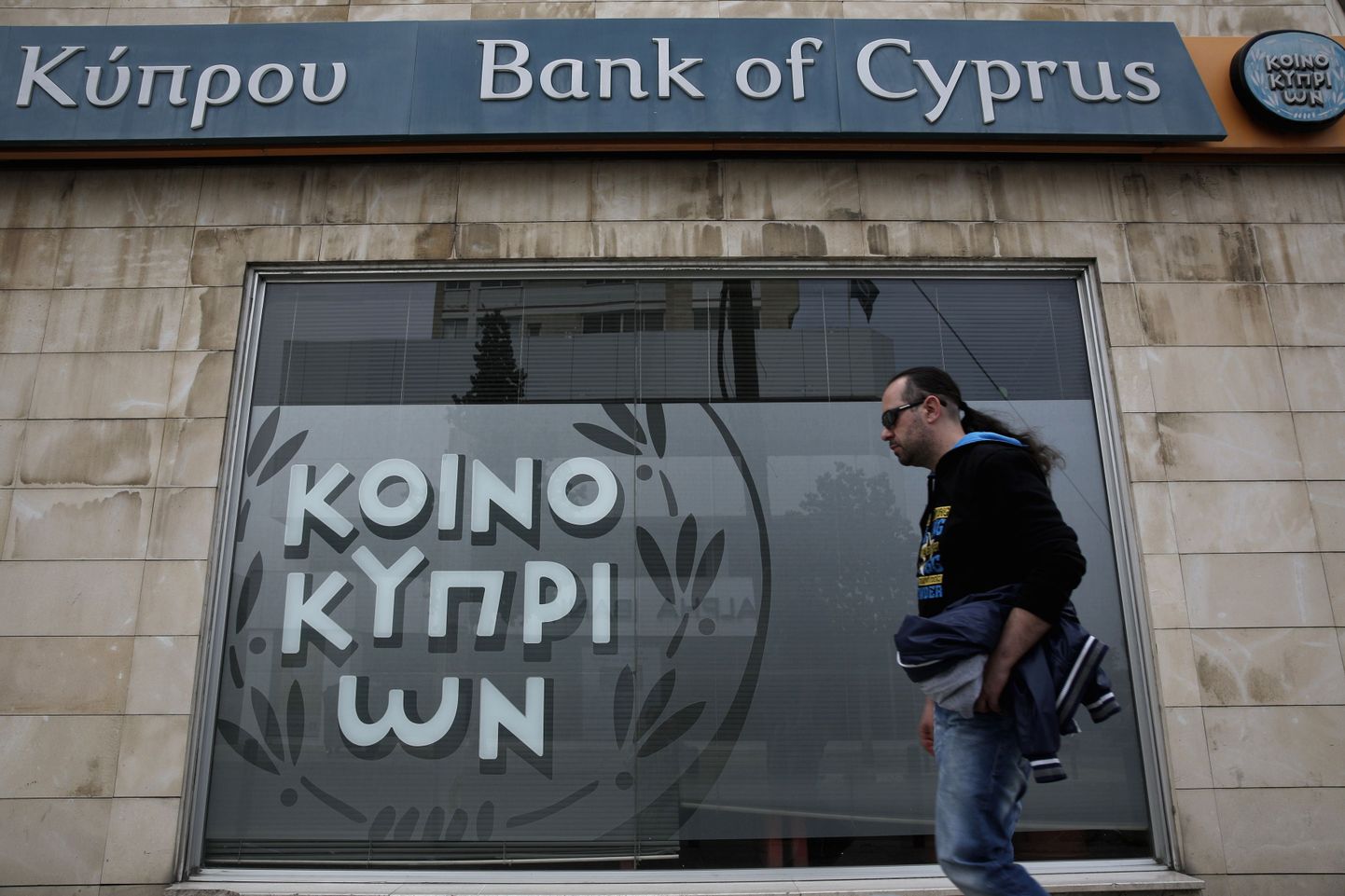 Mees Küprose pealinnas Nikosias Bank of Cyprus'e kontori ees.  Saareriigi suurima panga hoiustajad kaotavad üle 100 000 euroselt hoiuselt 60 protsenti, kinnitas riigi keskpank laupäeval.