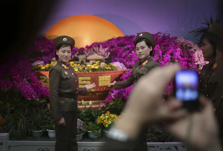 Военные позируют на фоне цветочной экспозиции на фестивале