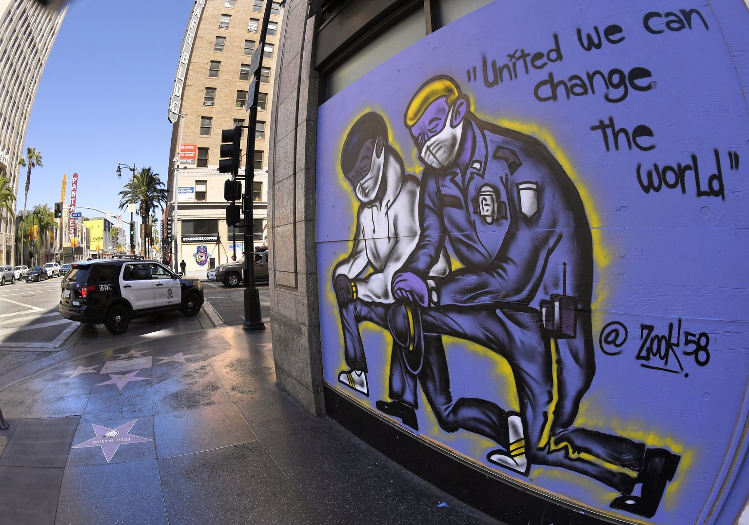 Seinajoonistus Los Angeleses, mille on kujutatud mustanahalist ja politsenikku koos
