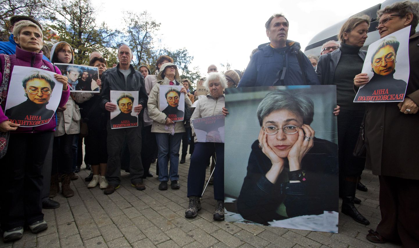 Demonstrators hold portrait of slain journalist Anna Politkovskaya during a rally marking the 6th anniversary of her death in central Moscow, on October 7, 2012, with Russian rights group Memorial founder, one of the nominees for this year's Nobel Peace Prize,  Svetlana Gannushkina (R) attending. Politkovskaya was gunned down in Moscow in 2006. AFP PHOTO / NOVAYA GAZETA/ EVGENY FELDMAN