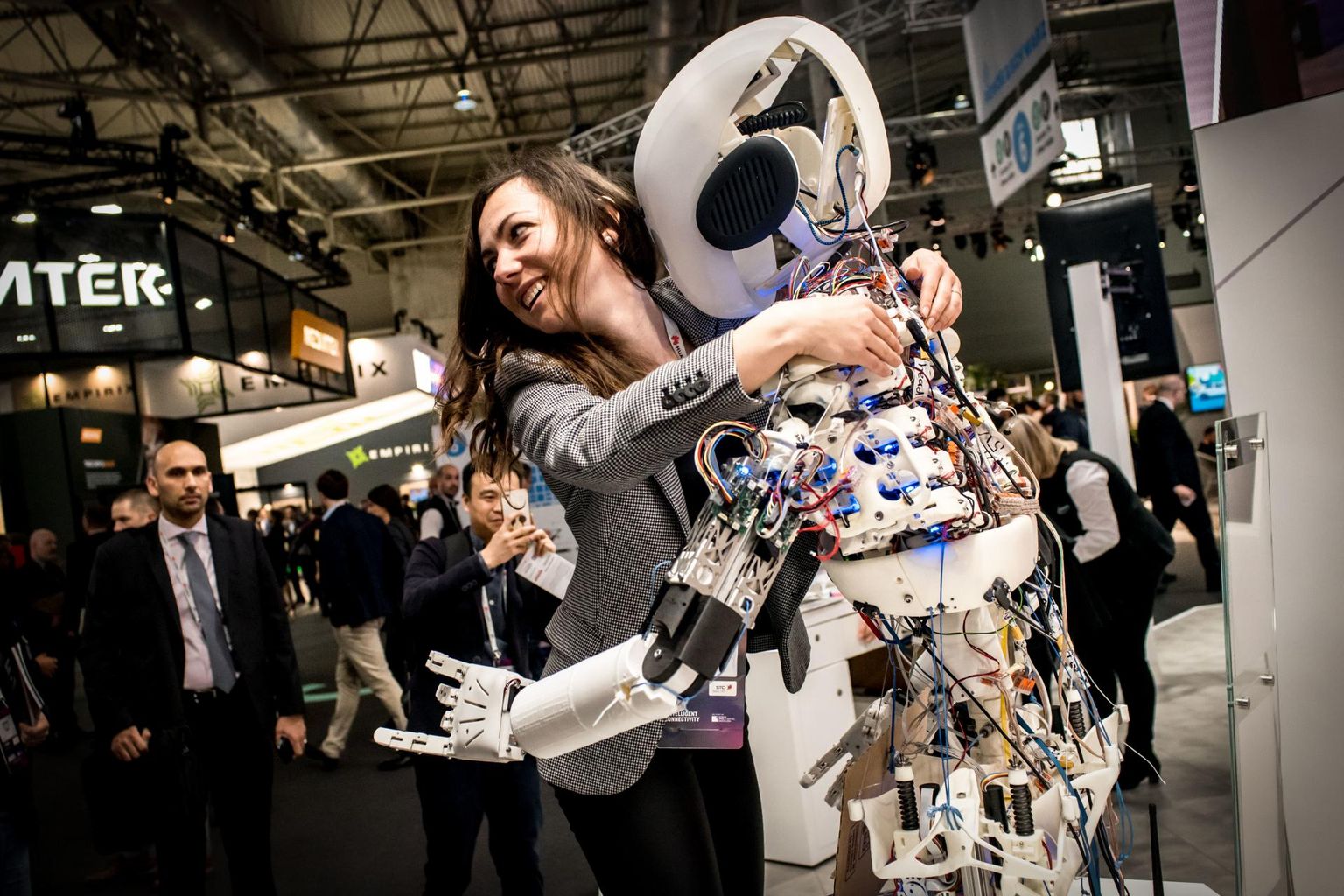 Naine embamas tasuta kallistusi jagavat robotit. 