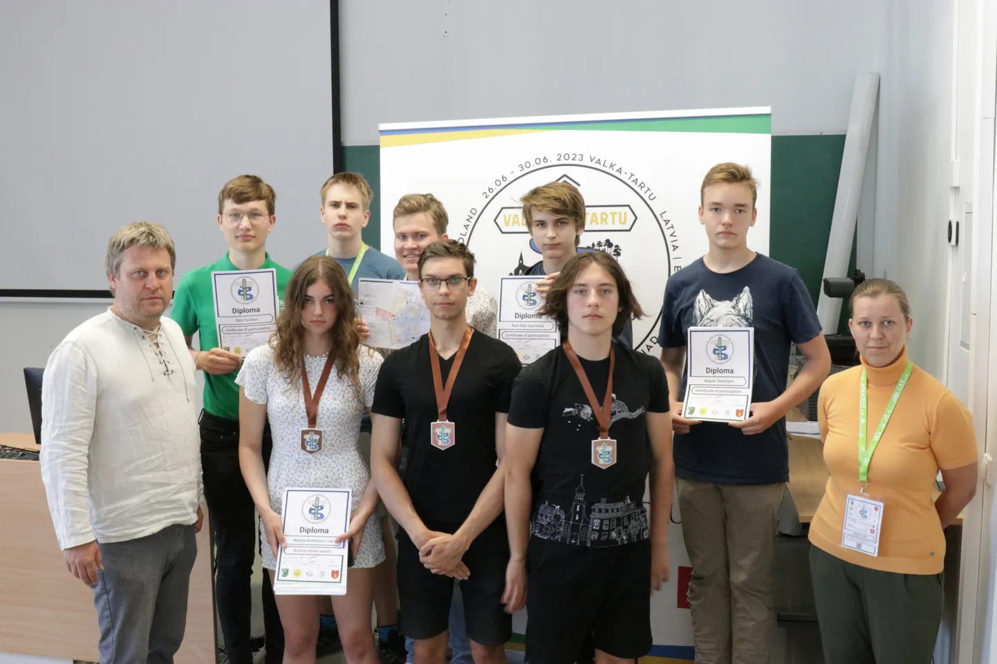 Eesti noored koos mentoritega lõputseremoonial. Alumisel real vasakult: Taavi Pae (mentor), Maarja Katherine Link, Gregor Ludvig Kikas, Arp Harald Tamm, Birgit Viru (mentor). Ülemisel real vasakult: Otto Tamkivi, Henri Ausin, Andre Viitamees, Rain Alar Laurimaa, Kaarel Tamman.