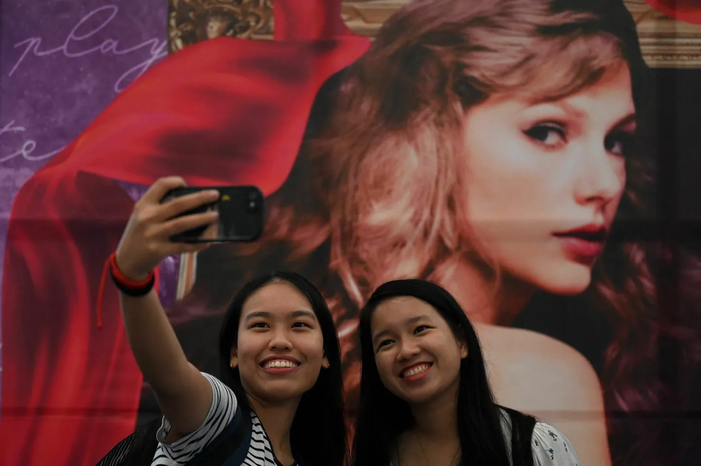 Juuli alguses jõudis megastaar Taylor Swifti tuur «The Eras Tour» Filipiinidele ja pool Manilat hullus. Fotol jäädvustavad paar fänni end Swifti plakati ees.
