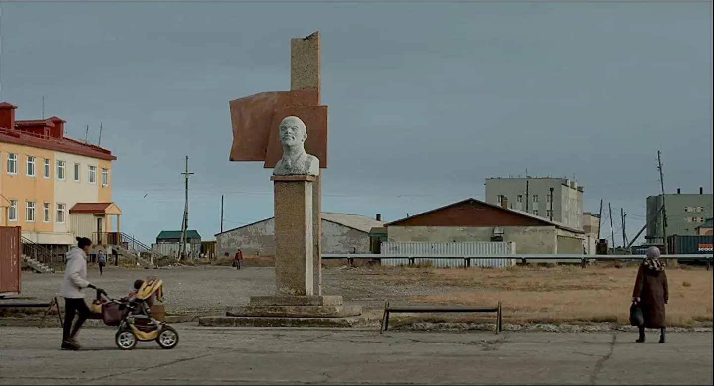 Dokumentaalfilm «Lorino valaskala». Klassikaline revolutsionääri ja riigiisa büst vaatab satelliidiantenni ja tossava korstna perspektiivi.   FOTOd: Filmikaadrid