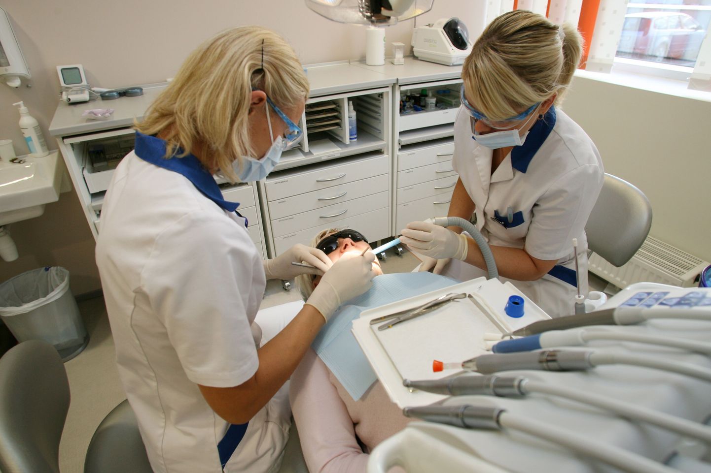 Tartu Medicum Dentali hambaarst ja ta assistent koos patsiendiga.