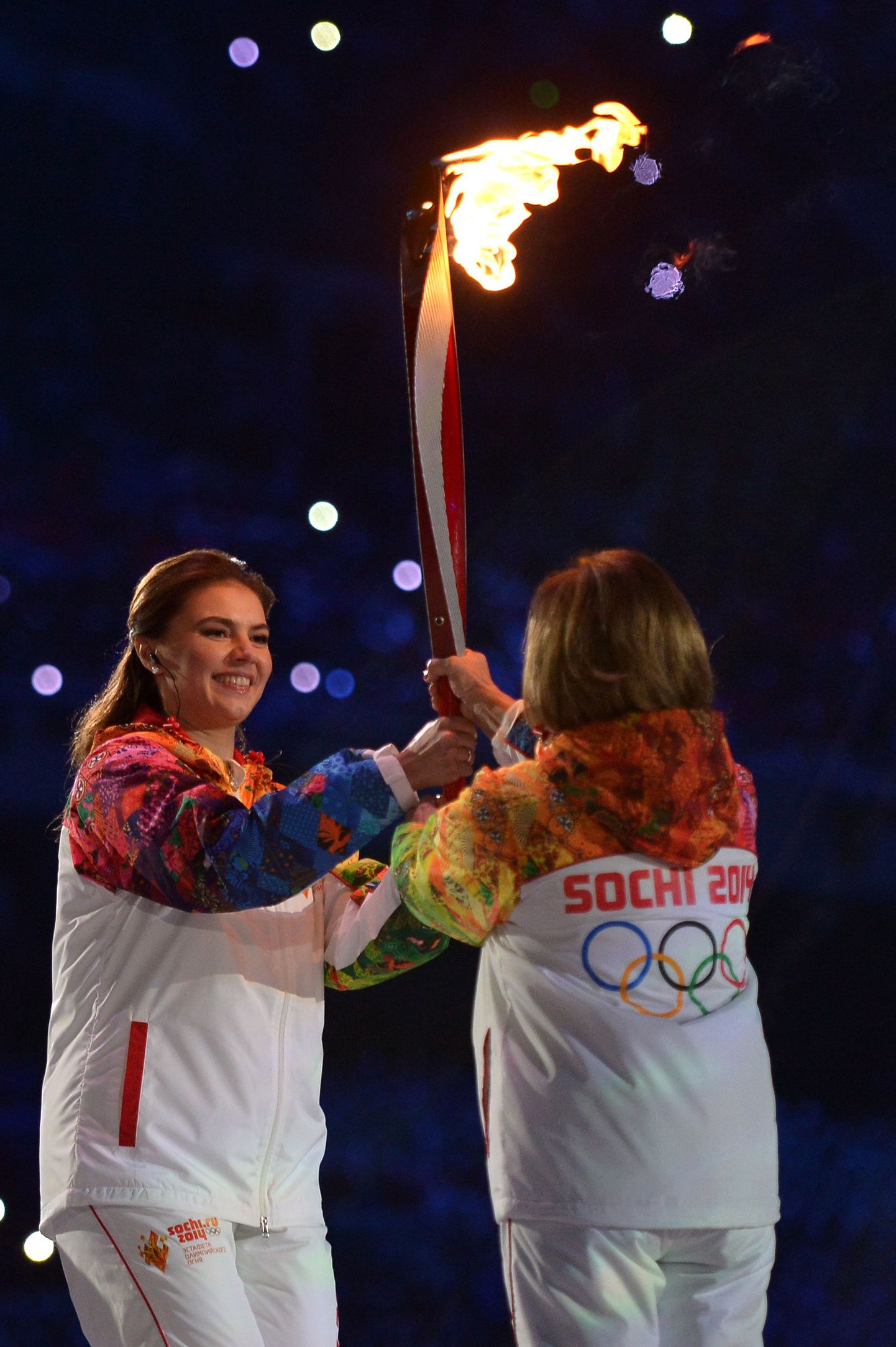 Alina Kabajeva (vasakul) andmas olümpiatule tõrvikut Irina Rodninale
