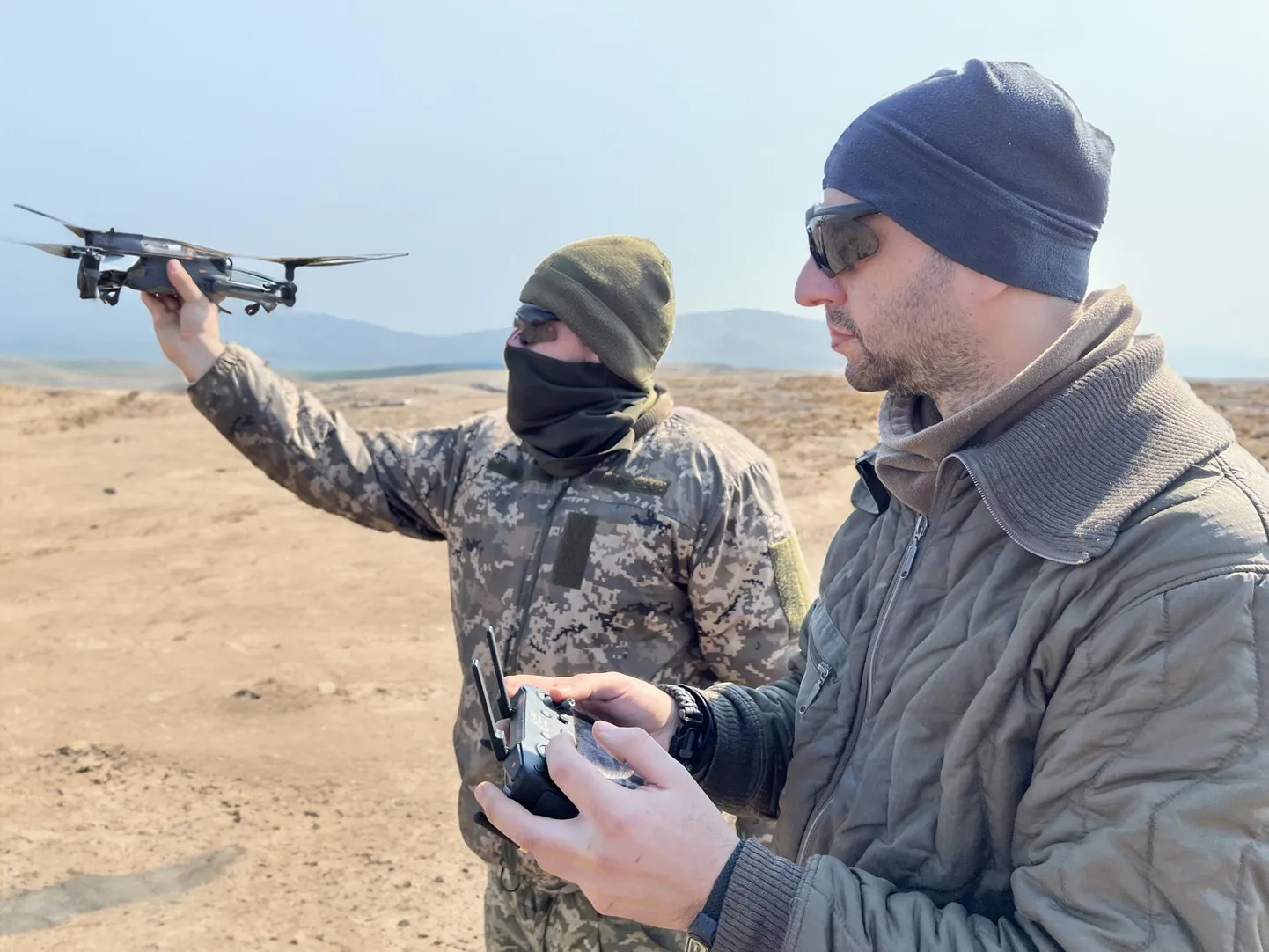31. brigaadi ühe õhudroonide üksuse juht kutsungiga Finn (tagaplaanil) oma sõduritega treeningul Donetski oblastis. Finn laseb lendu drooni, millega filmiti õppustel harjutamist. Esiplaanil on droonijuht. Sõdurite turvalisuse huvides on foto tausta tehisintellekti abil muudetud.