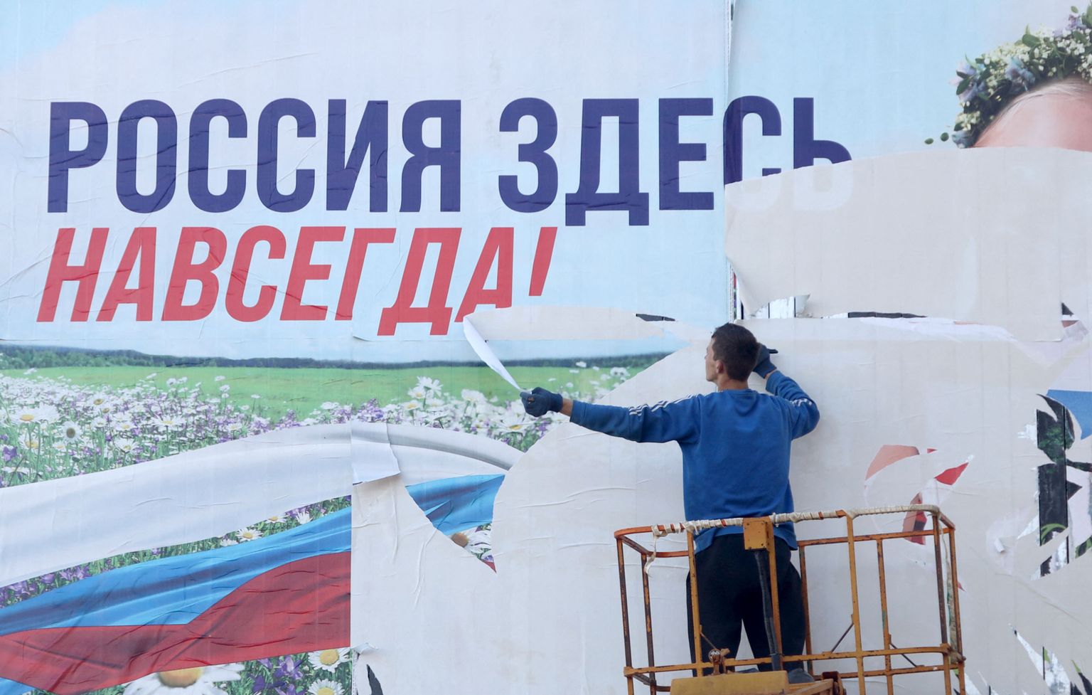 Рабочий в Херсоне рвет пророссийский баннер после освобождения.
