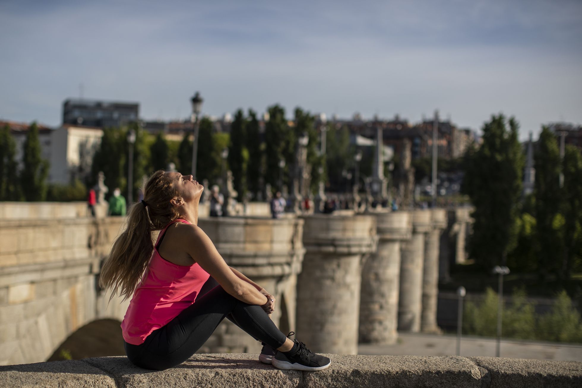 Теперь можно просто сидеть на солнышке и дышать воздухом, как делает эта девушка в Мадриде.