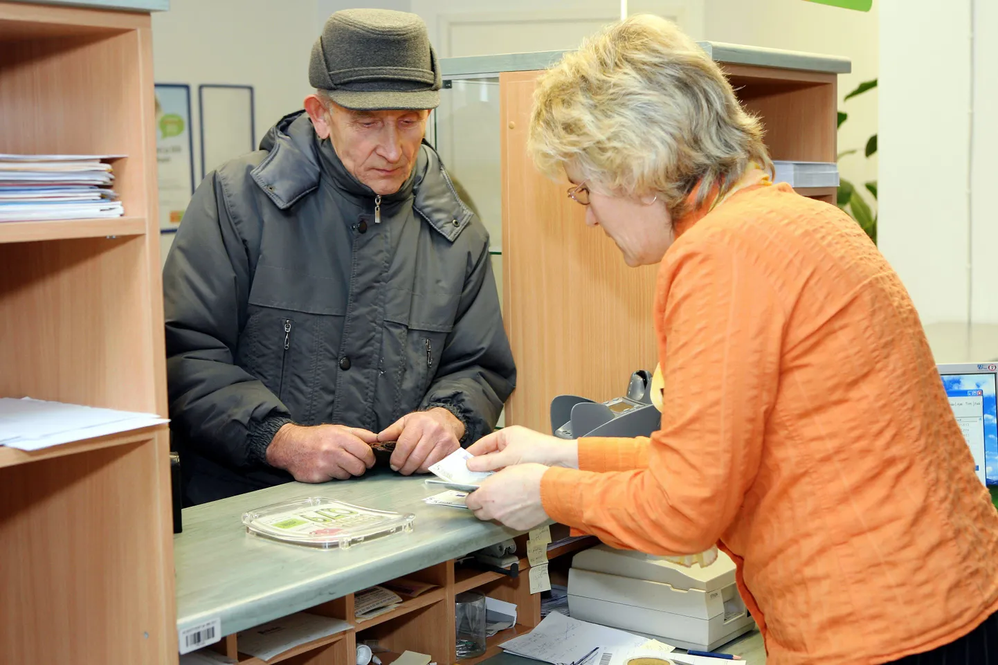 Postkontorid vahetasid kroone eurodeks 14. jaanuarini. Pildil Olustvere postkontori klienditeenendaja kroone eurodeks vahetamas.